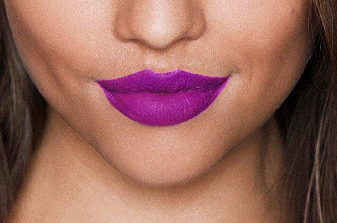 Jeune femme portant un rouge à lèvres liquide mat violet de Maybelline