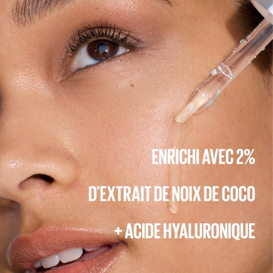 Une femme applique sur sa peau une goutte transparente de sérum inodore à l'aide d'une pipette.