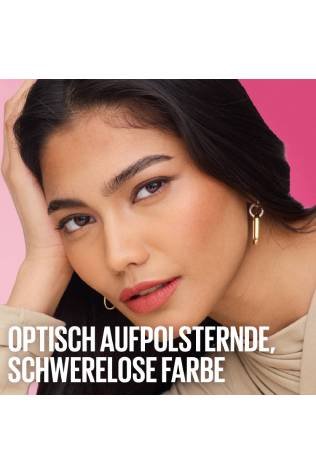 Gros plan sur une jeune femme aux cheveux sombres regardant l'objectif, la tête délicatement posée sur sa main, portant un rouge à lèvres couleur corail.